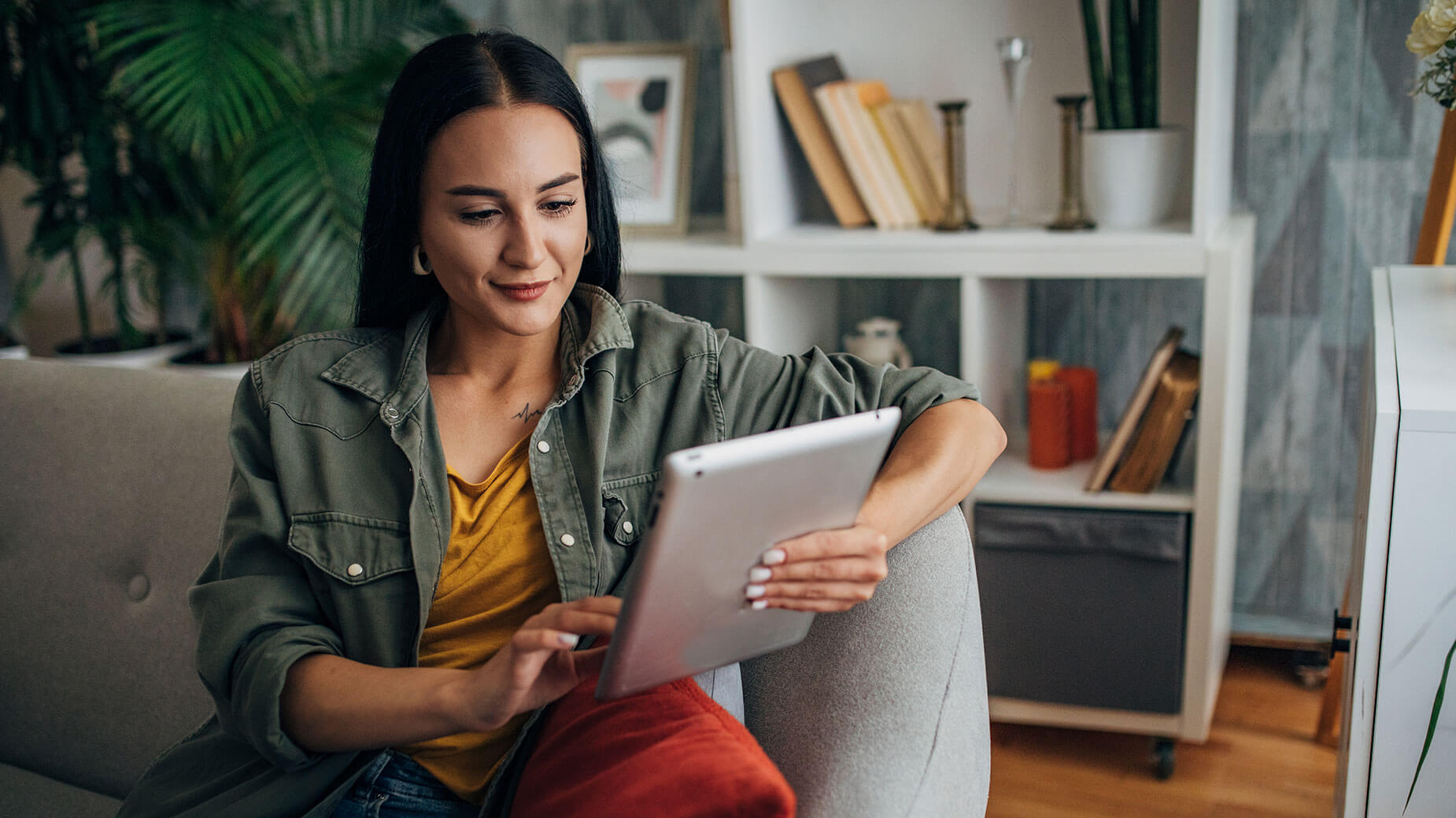 woman sitting on a couch using a tablet