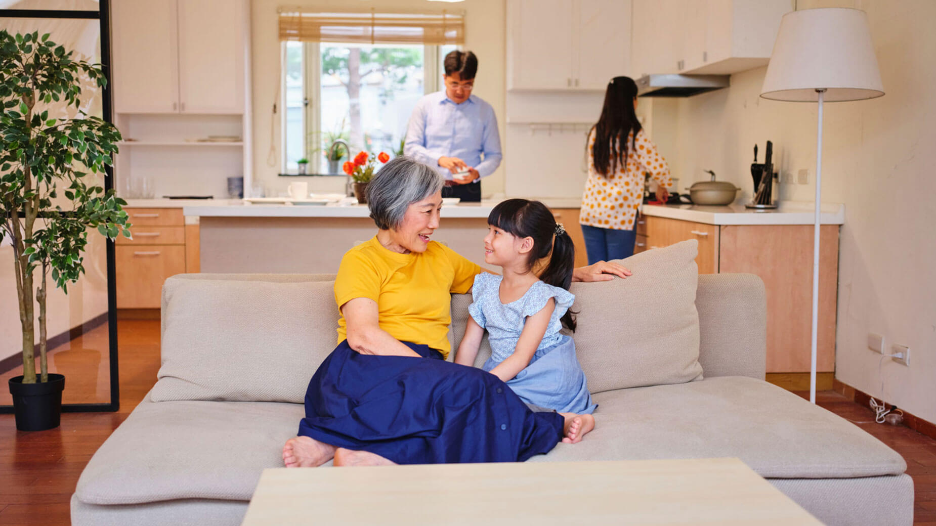 grandmother and granddaughter sitting on a couch in a home